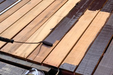 Ahşap zeminde boya silindirli işçi boyası.