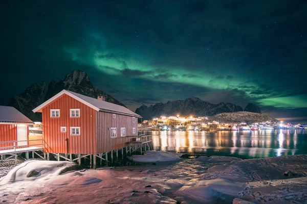 Κόκκινο ξύλινο σπίτι στο ψαροχώρι με aurora borealis πάνω Re — Φωτογραφία Αρχείου