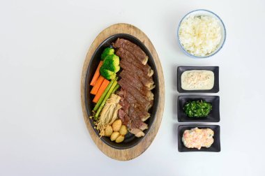 Japon wagyu sığır eti dilimleri tavada sebze ve sos ile ayarlanmış