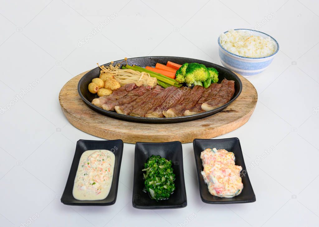 Japanese wagyu beef slices set with vegetables and sauce on pan