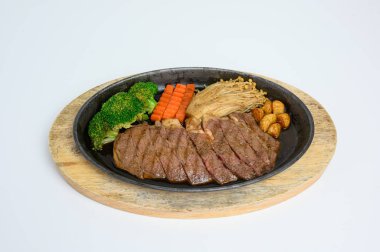 Japon wagyu sığır eti dilimleri ahşap tepside sebzelerle hazırlanmış.