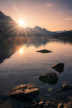 Jasper 'daki Medicine Gölü' nde kayalıklarda gün doğumu 