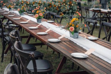 Kırsal düğün tarzı, çiçek süslemeli ahşap yemek masası.