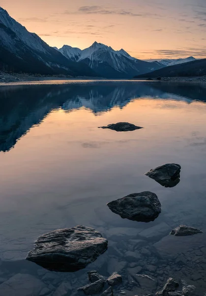 Nascer do sol na montanha rochosa com rochas no lago Medicine em Jasper — Fotografia de Stock