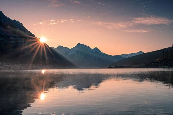 Nascer do sol na montanha com nevoeiro no lago Medicina em Jasper — Fotografia de Stock