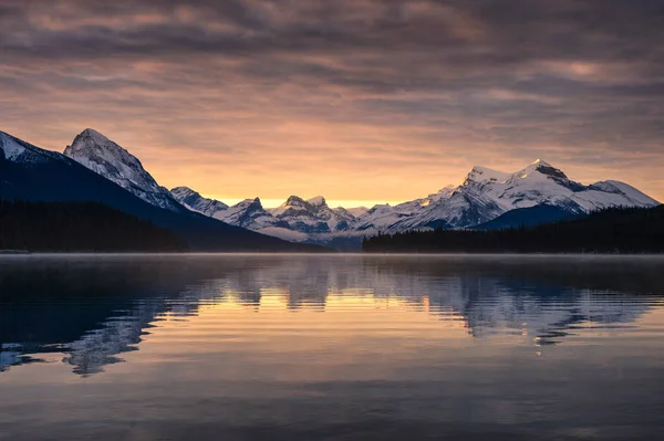 Rochas canadenses com reflexão nebulosa no lago Maligne e cor — Fotografia de Stock