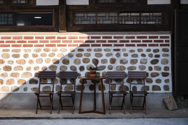 Wooden table and chairs on brick wall in cafe — 스톡 사진