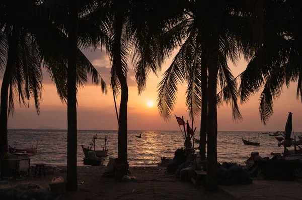 Puesta de sol en la playa con cocoteros y barco pesquero — Foto de Stock