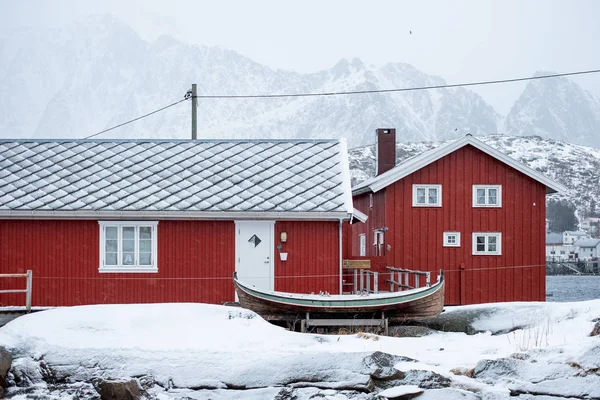 Karlı bir balıkçı köyünün ahşap kırmızı evi kışın kaplıydı. — Stok fotoğraf