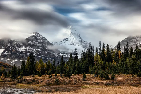 Monte Assiniboine com a nuvem que flui através da floresta de outono em — Fotografia de Stock