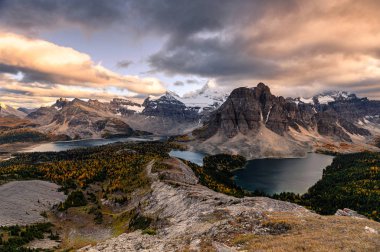 Mount Assiniboine with lake on Nublet peak in autumn forest on s clipart