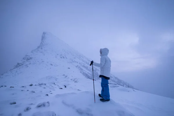 雪の山の頂上に立つトレッキングポール付きの男クライマー — ストック写真