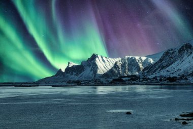 Aurora Borealis, Kuzey Işıkları Lofo 'daki karlı dağın tepesinde.