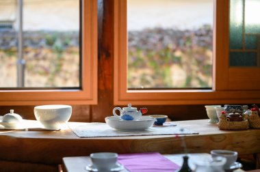 Sabah güneş ışığıyla seramik tabakta tahtada çay fincanı