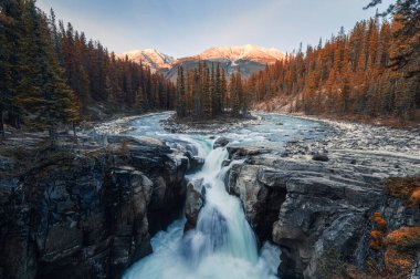 Sunwapta Falls is pair of the Sunwapta river in autumn forest at sunset. Icefields Parkway, Jasper national park, Canada clipart