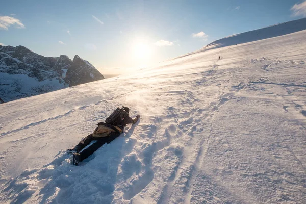 夕阳西下 摄影师在雪山上爬行 — 图库照片
