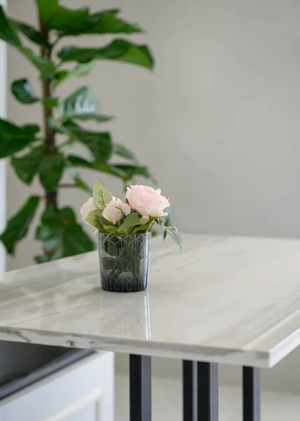 粉色玫瑰盛开在木制桌子上的玻璃中 — 图库照片