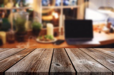 Bulanık dizüstü tahta masa. Bitki süslemesi ve parlak arka planı var. konsept evde kalmak, evden çalışmak