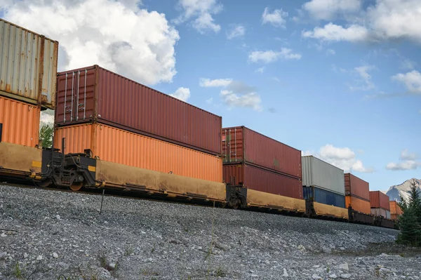 Train long freight passing with container loading on railway in valley at Calgary, Canada