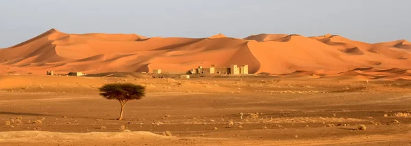 Casas berberes no sopé de deslumbrantes dunas de areia de Merzouga — Fotografia de Stock