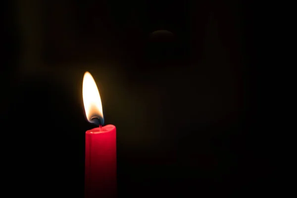 Одинарна горіння свічка в темряві — стокове фото