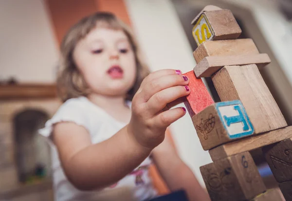 Chica jugando con bloques de construcción en el suelo —  Fotos de Stock