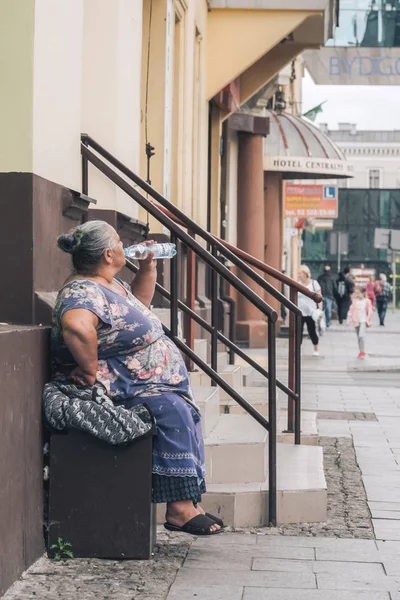 Oude vrouw drinkwater — Stockfoto