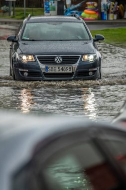 Su basmış bir sokakta araba