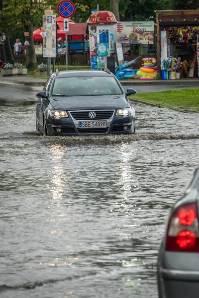 Su basmış bir sokakta araba