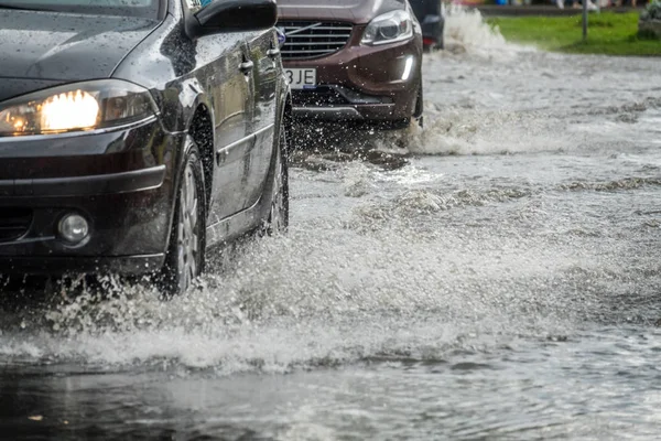 Su basmış bir sokakta arabalar