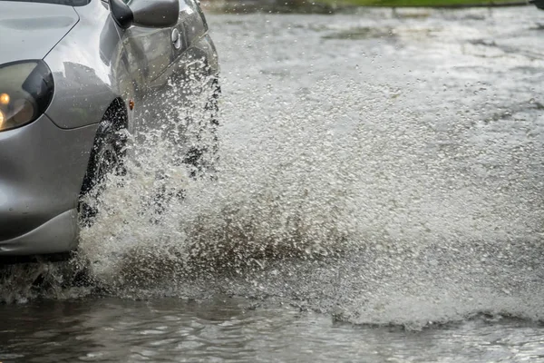 Su basmış bir sokakta araba