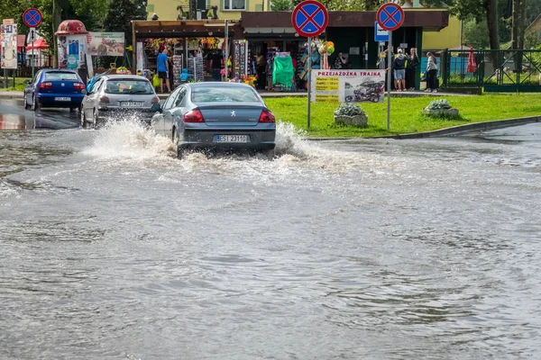 Su basmış bir sokakta arabalar