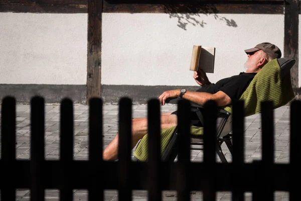 Livro de leitura em um alpendre de uma casa — Fotografia de Stock