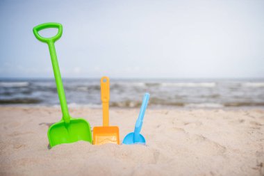 Üç renkli oyuncak kürek sahilde