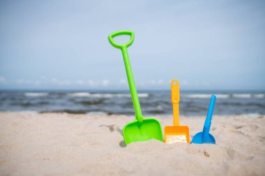 Üç renkli oyuncak kürek sahilde