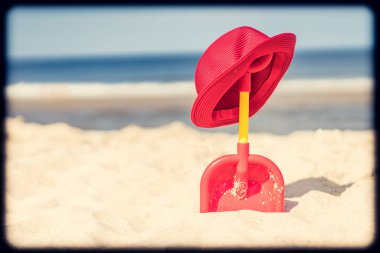 Kırmızı kürek ve sahilde hasır şapka