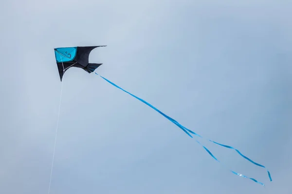 Cometa negra y azul volando alto en el cielo — Foto de Stock