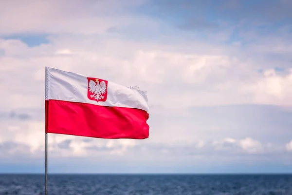 Красно-белый польский флаг с Балтийским морем на заднем плане — стоковое фото