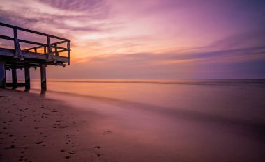 Günbatımı deniz sahilde ahşap iskele üzerinde