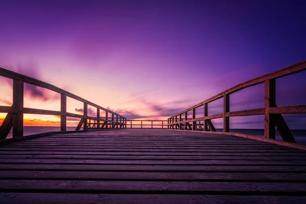 Houten pier op het strand bij zonsondergang — Stockfoto