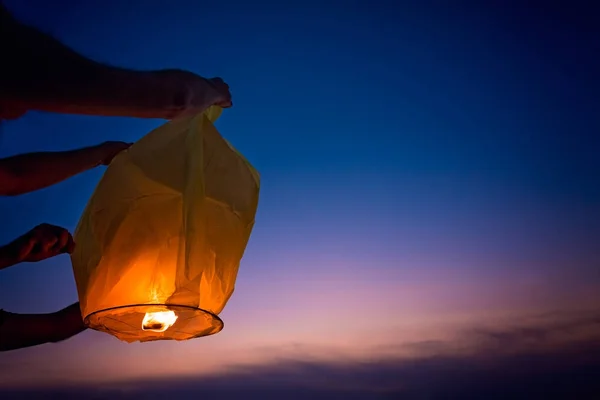 Människor ställa ut kinesiska lantern i solnedgången — Stockfoto