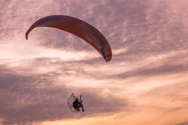 Gleitschirm fliegt in der Abenddämmerung über den Strand — Stockfoto