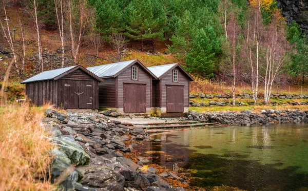 Três cabanas de madeira na margem de um fiorde — Fotografia de Stock