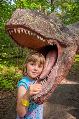 Küçük kızlar kafa bir dinozorun ağzına 