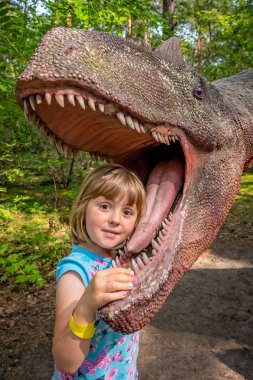 Little girls head in the mouth of a dinosaur  clipart