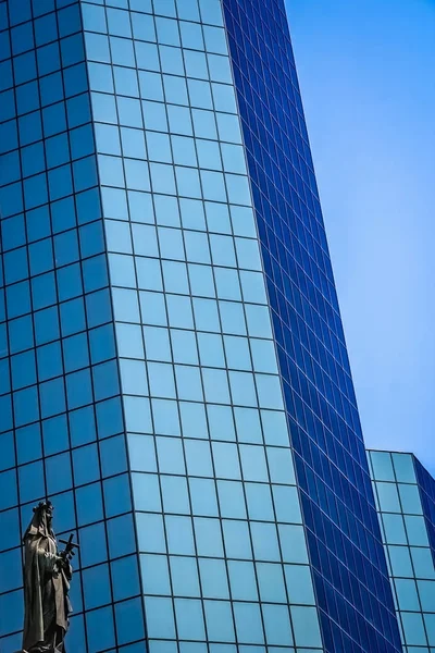 Estátua de santa Maria em frente ao edifício de escritórios de vidro moderno em — Fotografia de Stock