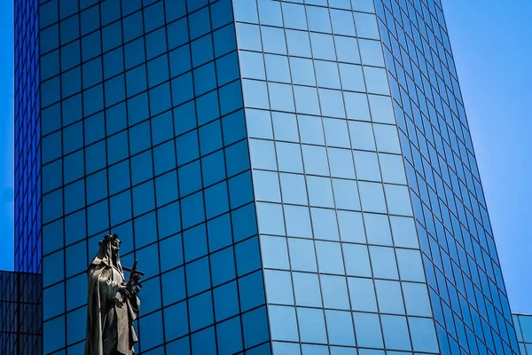 Statua di Santa Maria davanti al moderno edificio per uffici in vetro — Foto Stock
