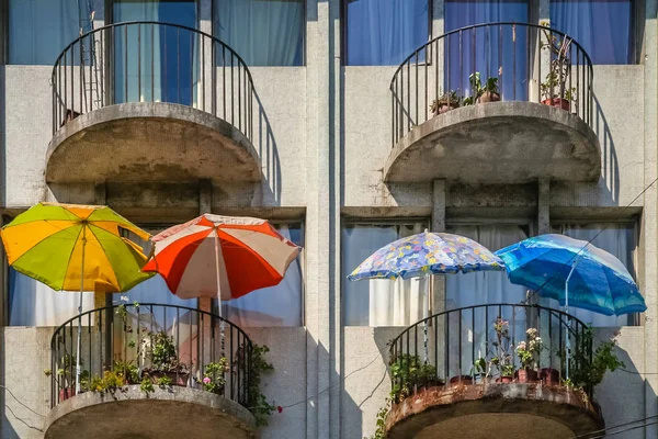 Färgglada paraplyer på balkongerna — Stockfoto
