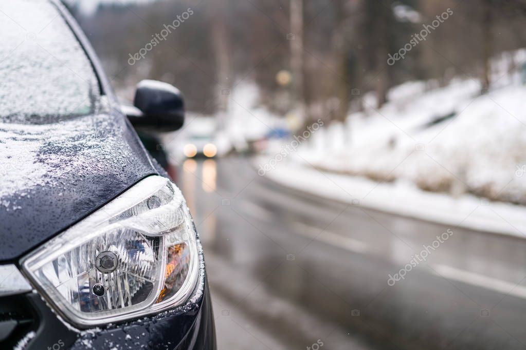 Close up of a light of a car parked on the roadside in winter