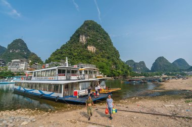 İnsanlar Yangshuo 'daki Li Nehri kıyısında feribottan iniyorlar.